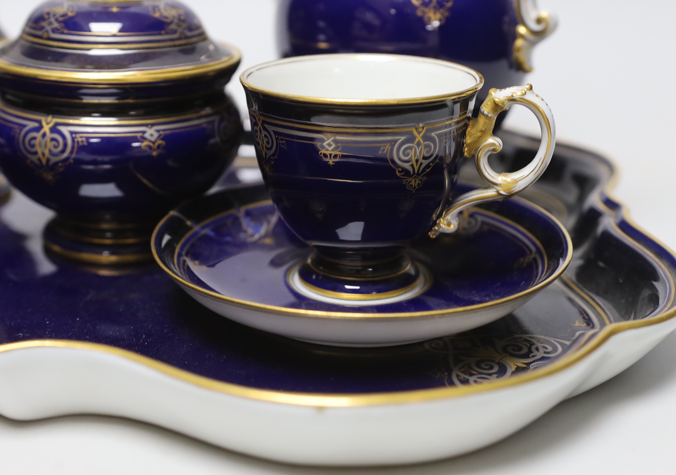 A late 19th century Meissen cabaret set comprising sugar bowl and cover, teapot and cover, creamer, two cups, a saucer and a tray (a.f.)